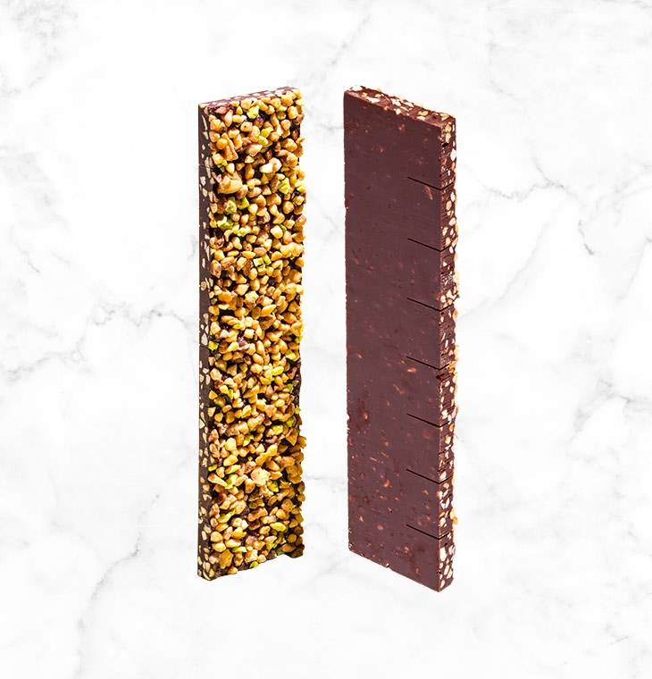 A crunchy mixture of almonds, pistachios and hazelnuts on a thin layer of dark chocolate, creating the perfect bar to share, presented in an elegant and brightly colored box.